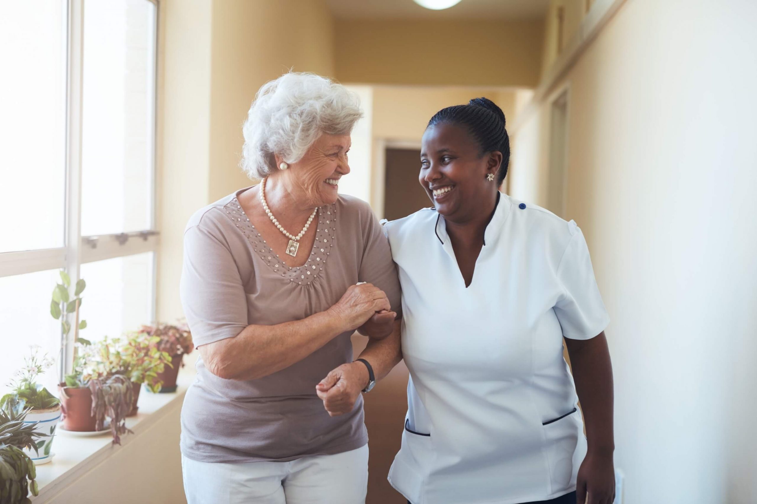 A smiling home caregiver and a senior.