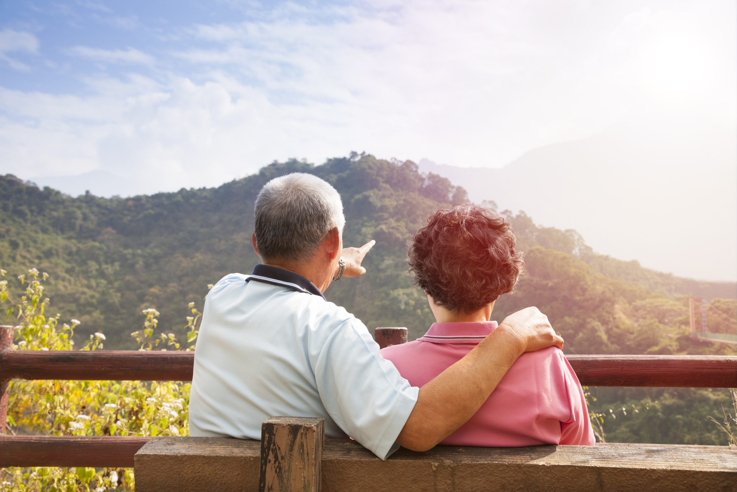 a senior couple sits on a bench taking in the views of a New Jersey state park