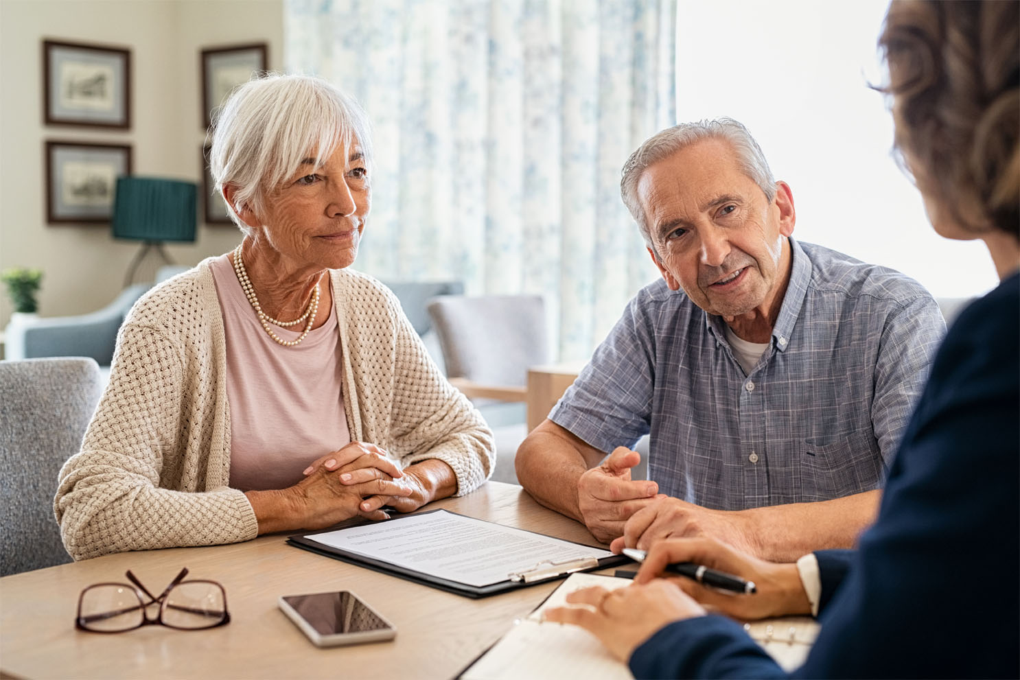 a senior couple meets with a home care agency representative to learn about their hourly senior in-home care options
